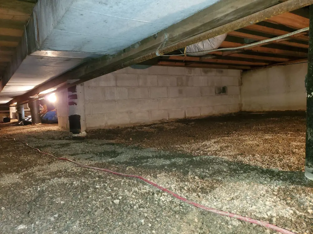 Open crawlspace with bare dirt and gravel floor before encapsulation