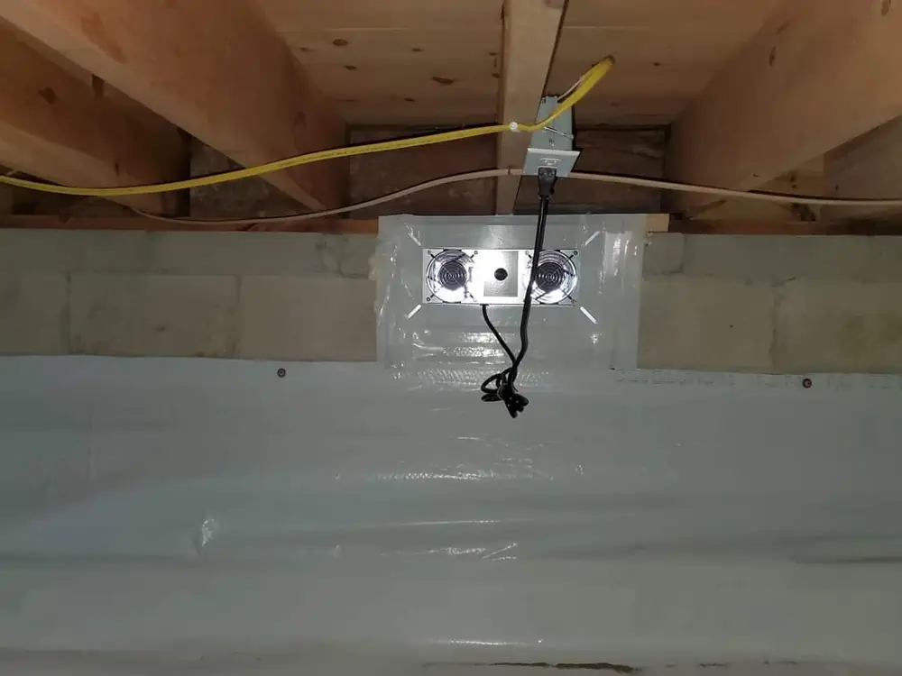 Crawlspace wall with white liner and a new electrical outlet