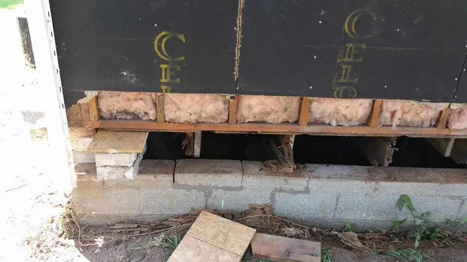 House exterior with the skirting opened up for crawlspace work