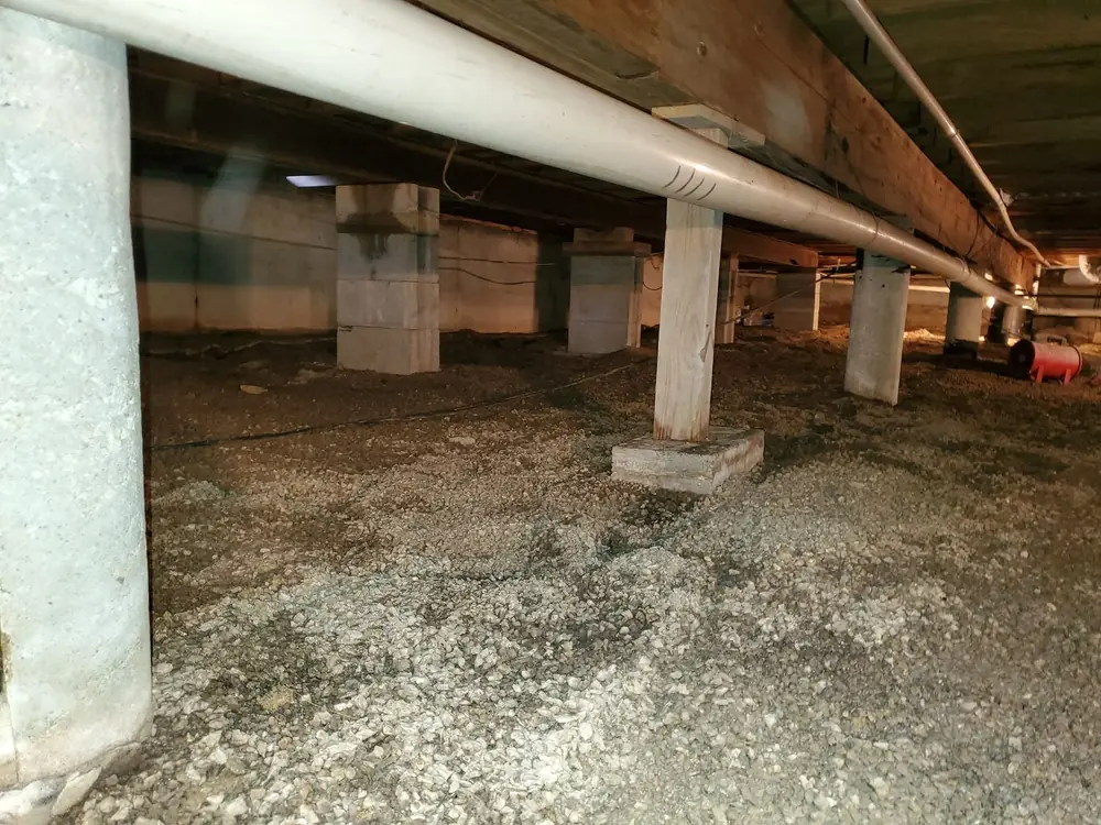 Open crawlspace with bare dirt and gravel floor before encapsulation