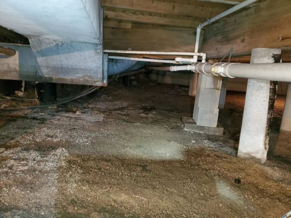 Open crawlspace with bare dirt and gravel floor before encapsulation