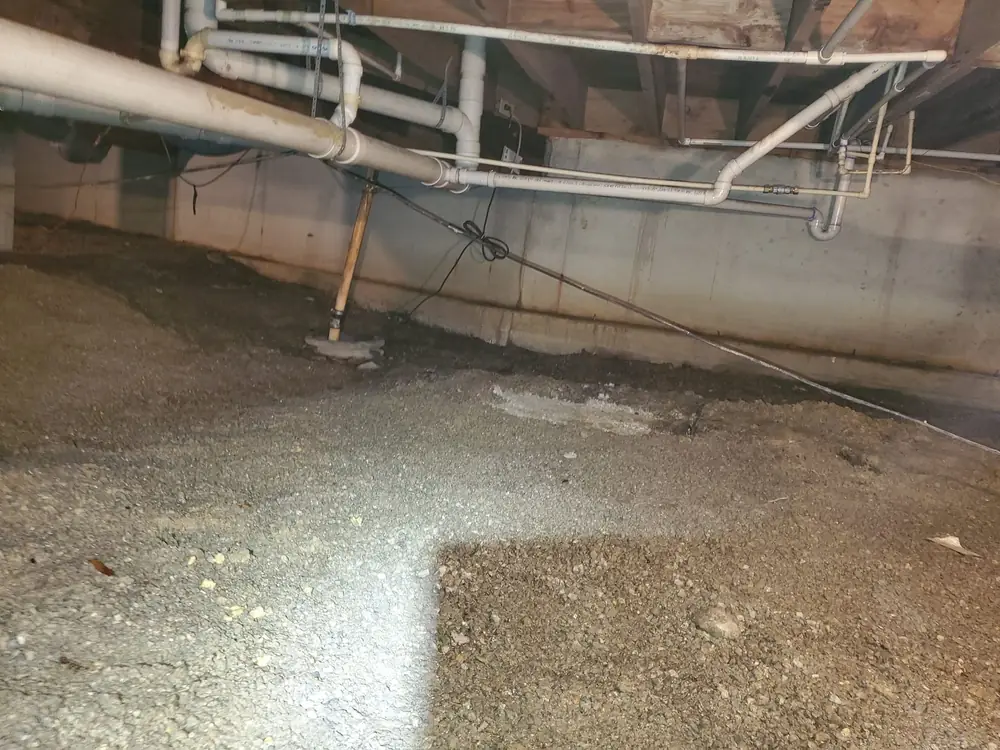 Open crawlspace with bare dirt and gravel floor before encapsulation