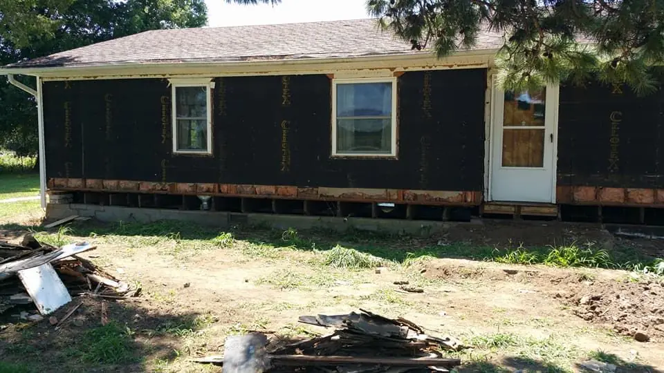 House exterior with the skirting opened up for crawlspace work