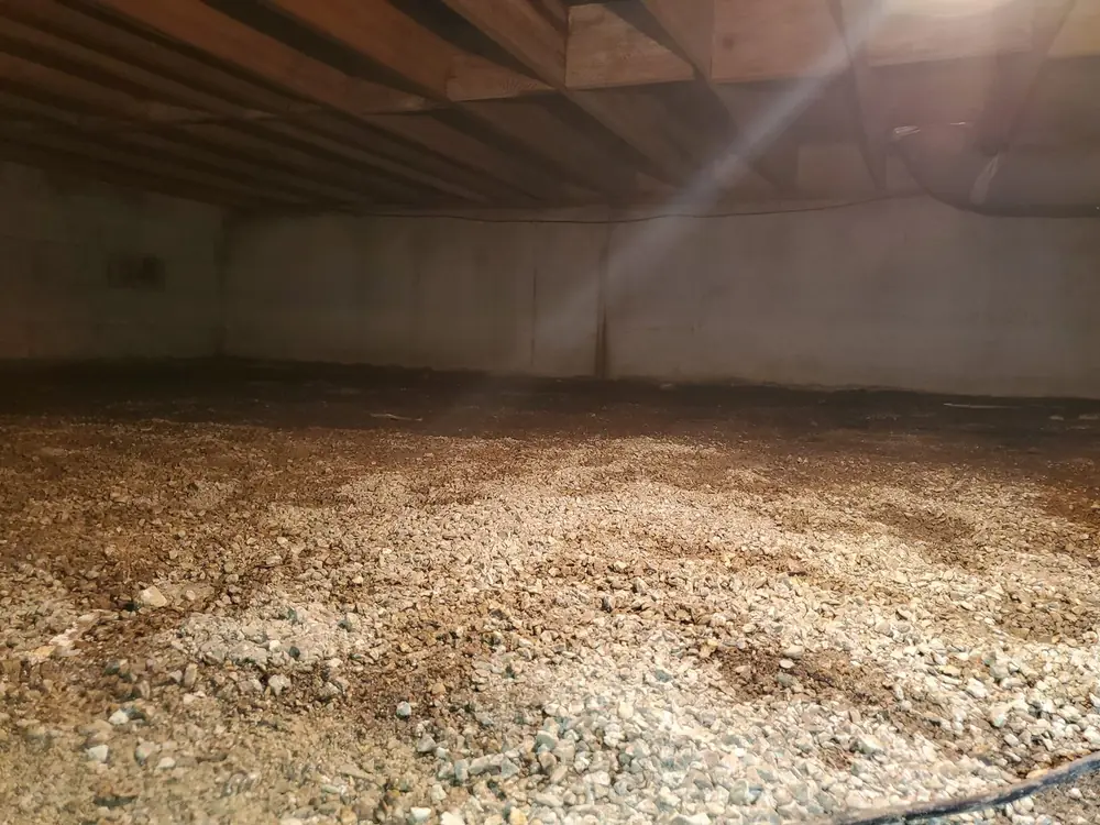 Open crawlspace with bare dirt and gravel floor before encapsulation